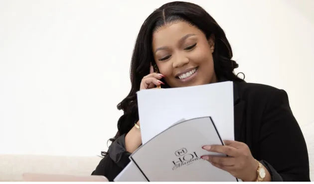 House of Intelligence consultant on a phone call holding an HOI Marketing folder